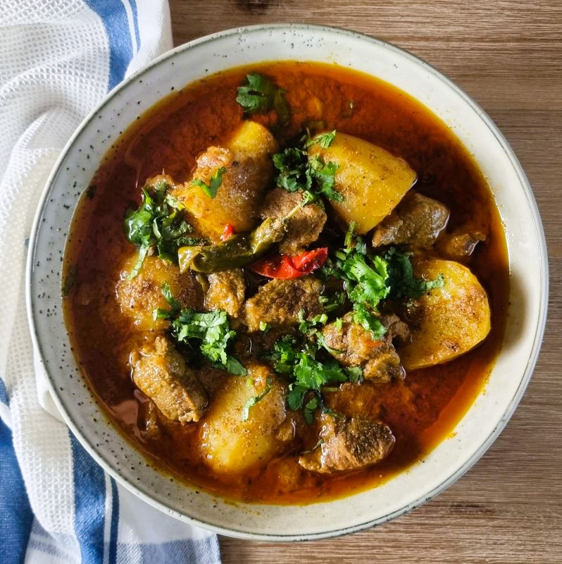 Traditional Pakistani Aloo Gosht with meat and potatoes garnished with coriander