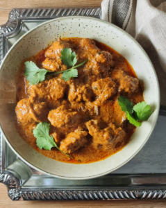 Authentic Chicken Korma in a plate with Coriander garnish