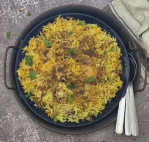 Vibrant Hyderabadi biryani with golden basmati rice, juicy chicken, and fresh herbs