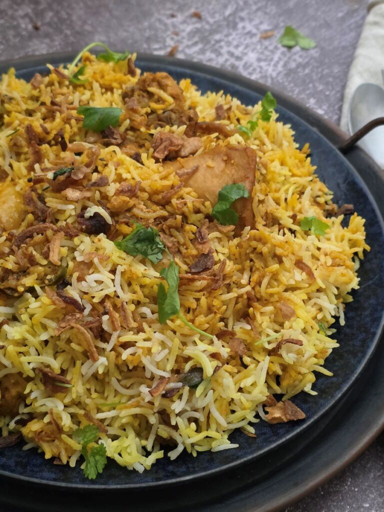 Vibrant Hyderabadi biryani with golden basmati rice, juicy chicken, and fresh herbs