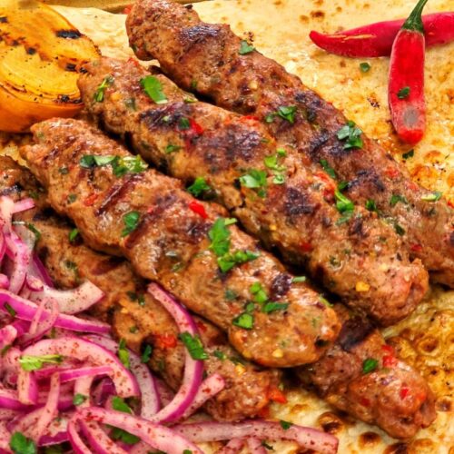 Turkish Adana Kebabs served on Lavash Bread with Onion sumac salad