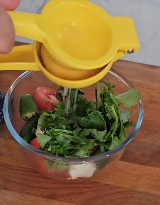 Squeezing lemon juice in tomato chutney