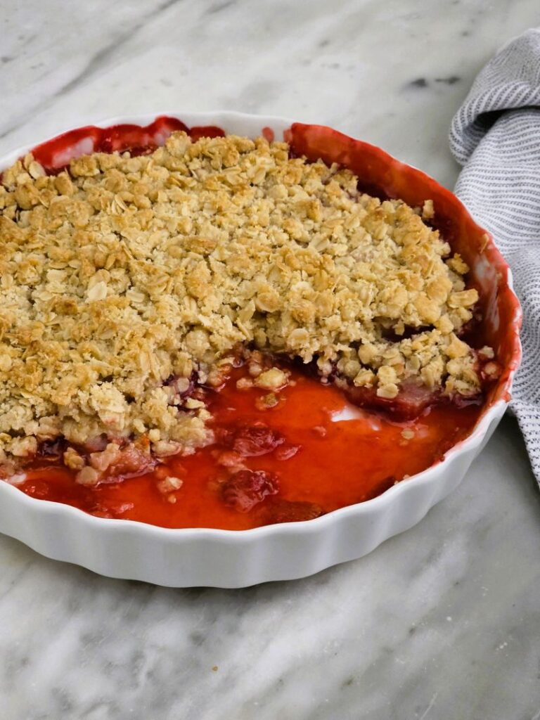 Close-up of strawberry crumble with juicy berries bubbling under crisp topping