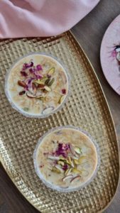Rich creamy Sheer Khurma in bowl topped with nuts and dates