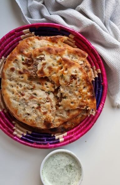 Soft, fluffy stuffed keema naan with juicy, spiced minced meat inside, showing the flavorful interior.