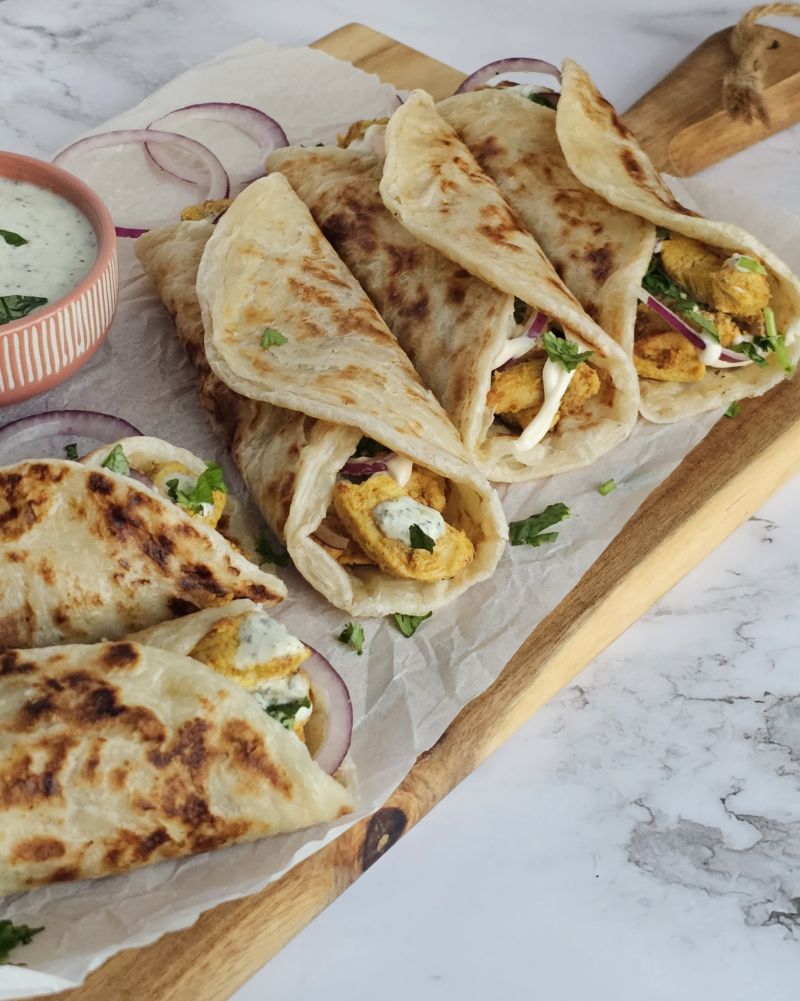 Quick & Easy Chicken Paratha roll served on a wooden serveboard with mint chutney on side