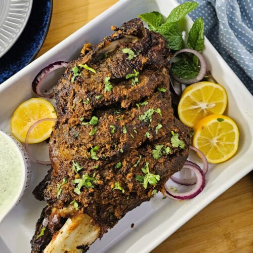 Mutton Leg Raan Roast in a platter served with mint raita