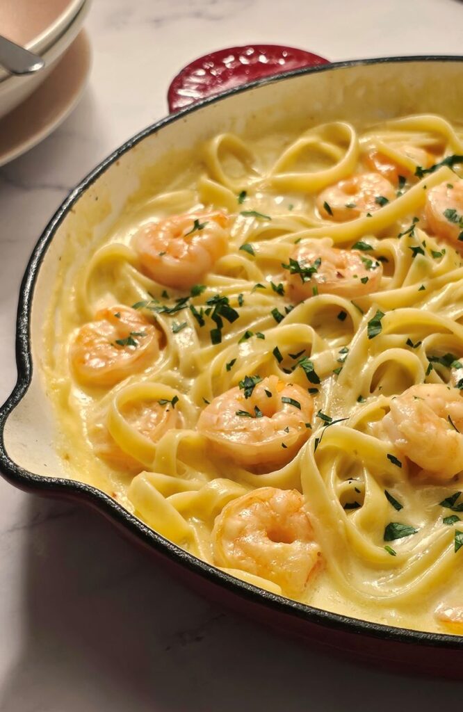 creamy garlic prawn pasta in a skillet