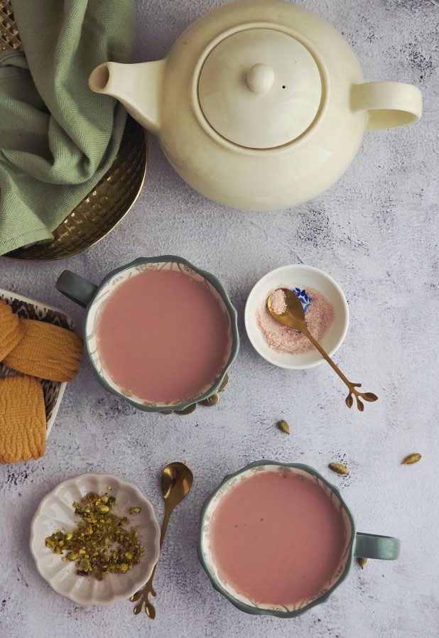 Overhead shot of creamy pink Noon Chai with cardamom and nuts
