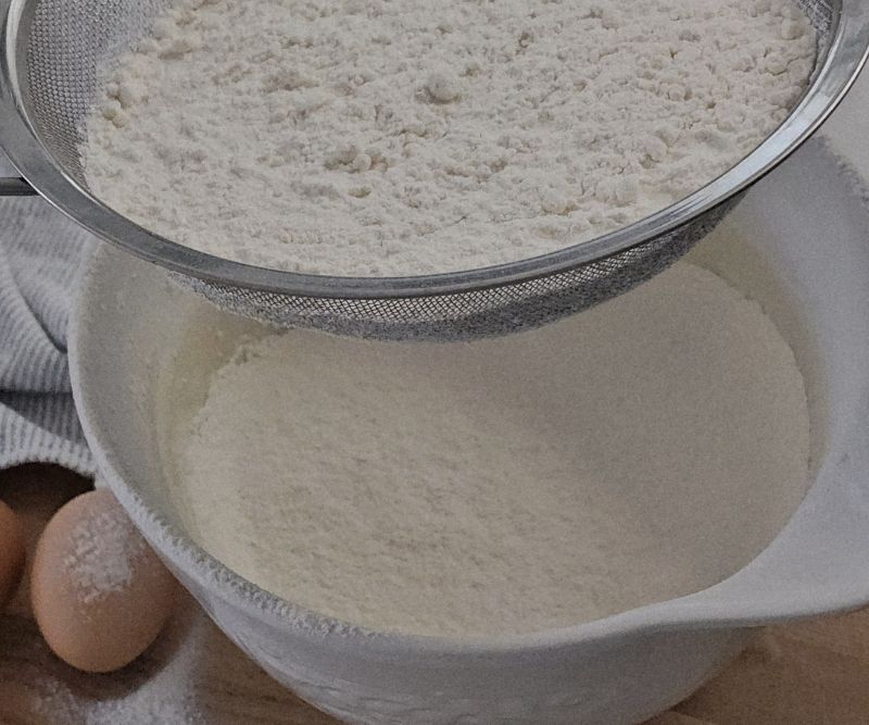 Dry ingredients (flour, baking powder, bicarb, and salt) sifted into a mixing bowl.