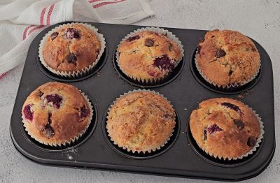 Golden raspberry chocolate chip muffins fresh out of the oven in a muffin tray